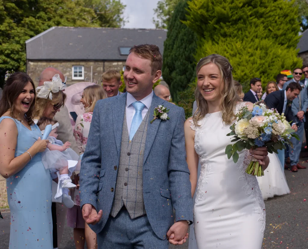Photo of the bride and groom doing a confetti walk by dick Lloyd Photography