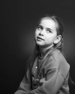 Studio black & white image - half body shot of a young girl with soft lighting