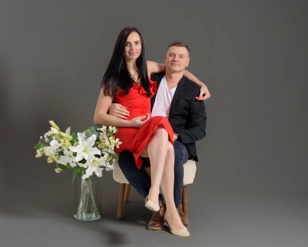 Indoor portrait of a couple using a neutral grey background and props for a calm, minimal studio aesthetic.”