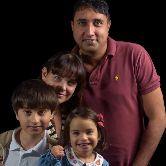 Varghese Family - 3196 square 560px-1 Family photographer Harrogate created this relaxed family portrait taken on location at the family's home, with black background.