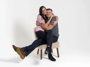 A couple sitting in a chair embracing.