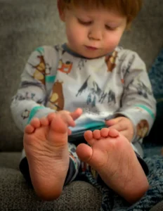 Joyful toddler girl laughing during a portrait session, captured in soft studio lighting for a children’s photography collection.