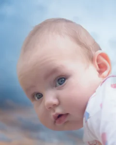 Baby headshot - pastel coloured background, soft light, by Dick Lloyd Photography