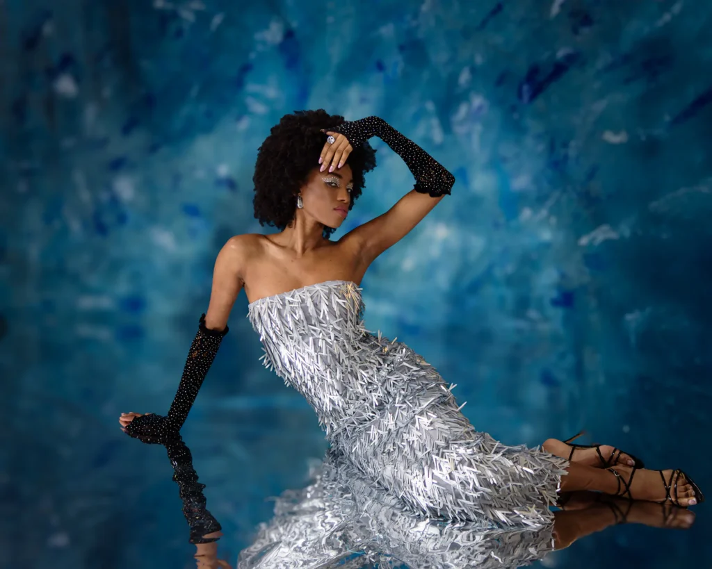 Winter Wonderland (2 of 2) Full body portrait of Black model before blue backdrop, captured by model portfolio photographer Harrogate Dick Lloyd.