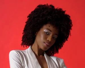 Headshot of a female model with a red background by Dick Lloyd Photography