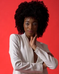 Half body shot of female model wearing a white jacket with a red background by Dick Lloyd Photography