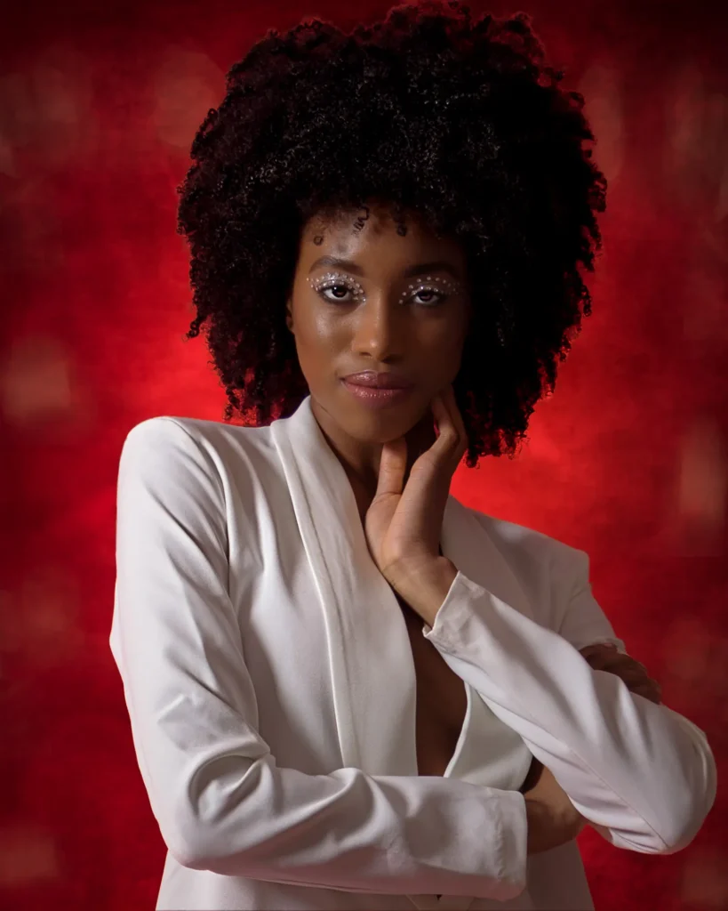 Winter Wonderland-3587-Edit-Edit Actor portfolio portrait of woman in white jacket against red background, taken in Harrogate studio.