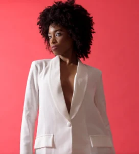 Half body shot of female model wearing white jacket with a red background by Dick Lloyd Photography