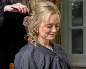 Bride having her hair styled before the ceremony.