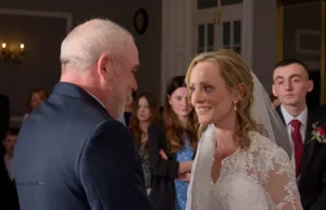 Bride and groom smiling warmly at each other during the ceremony.