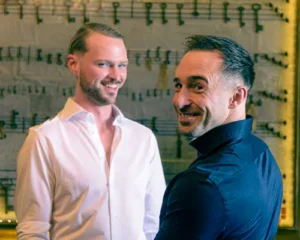 The grooms smiling together during their wedding day.