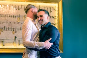 Grooms sharing a joyful hug during their wedding celebration.