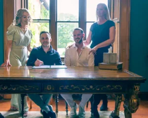 The grooms signing the register with their witnesses